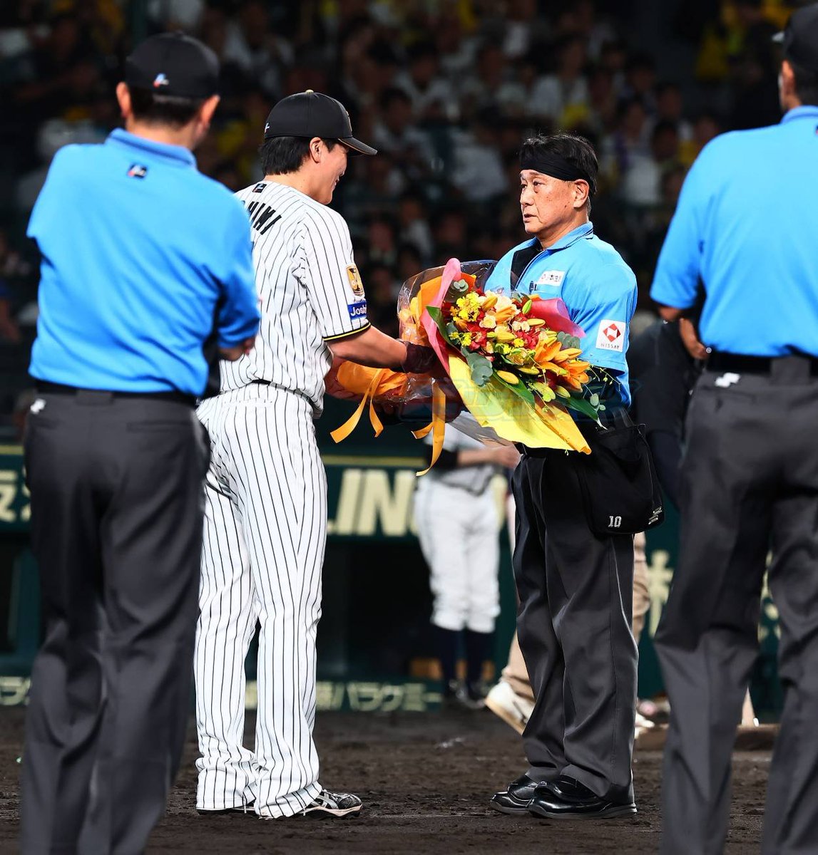 NikkanNaruohama's tweet photo. 球審を務めている名幸一明さんが通算2000試合出場の節目を迎えました✨️
試合成立の５回終了後に伏見寅威選手から花束が㊗️
おめでとうございます🎊
現役最多は真鍋さん。今年、3000試合の表彰を受けています😊
#審判 https://t.co/L577kuV3Y0