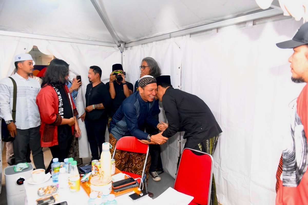 salimafillah's tweet photo. GUS-nya PARA GUS
Menyambut Gus Kautsar di Padhang Bulan Fest

Ada fenomena Gus-gusan yang meresahkan. Tapi Gus-Gus sejati seperti Gus Baha' dan suami dari 'Eyang putri-nya' Gus Baha' ini (Ning Jazil), melegakan kita dengan ilmu, nasehat, dan kesahajaan mereka.

Kita memang tak patut menganggap seorang manusiapun di zaman ini suci di hadapan Allah. Tapi dengan keluasan ilmu, mahfuzhat 'ibarat, kebernasan fahaman, keadilan timbangan, dan pengertian yang mendalam akan fiqih dakwah dan keadaan ummat, Gus Kautsar telah membawa kecerahan bagi ummat.

Luwes karena manthiq yang kokoh dan santun karena balaghah yang mantab khas fuqaha' Syafi'iyyah, faham perbandingan madzhab dan amat mengetahui variasi aqwal para 'ulama, ketat pada diri tapi membawa keluasan bagi ummat. Bertabur berbagai 'ibarat dari kitab-kitab turats penuh hikmah di setiap nasehatnya. Bersama Gus Kautsar, fiqih kembali pada ashalahnya, "Sesungguhnya Allah menghendaki kemudahan bagimu dan bukan menginginkan kesukaran untukmu", dan "Allah tidak menjadikan kesempitan di dalam agama." Bersama Gus Kautsar pula, kitab Ihya' 'Ulumiddin terasa begitu relevan dengan keseharian dan kekinian, menegur dan menyindir telak kebebalan diri.

Bagi yang dekat, hadirilah majelisnya. Bagi yang jauh, carilah majelis serupa. Sungguh tiap langkah ke sana dihitung memudahkan jalan ke surga. Betapapun kini kita dimudahkan oleh internet dan media sosial untuk menggapai ilmu, berkah tapak-tapak jalan ke pengajian itu tak tergantikan. Berkah ilmu kian langka. Hingga kadang di bawah video indah berisi ilmu manfaat seorang ustadz, berjajar serapah para pro dan kontra.

Dan di majelis-majelis semacam asuhan beliau, ada yang lebih bernilai dari ilmu. “Sebab pada guru yang sebenar berilmu”, begitu ditulis Ibn ‘Athaillah, “Kan kau reguk adab yang tak disediakan oleh buku-buku.”

“Kita lebih berhajat pada sedikit adab”, ujar Imam ‘Abdullah ibn Al Mubarak, “Daripada berbanyak pengetahuan.” Demikianlah di kala lain beliau menyatakan bahwa dirinya memerlukan waktu 30 tahun untuk belajar adab, ditambah 20 tahun untuk belajar ilmu. “Adapun ilmu yang kuhimpun dari seluruh penjuru raya selama dua dasawarsa”, simpulnya, “Sama sekali tak bernilai tanpa Adab yang kulatih sebelumnya.”
.

"Hampir-hampir Adab itu", tegas beliau, "Adalah dua pertiga agama."