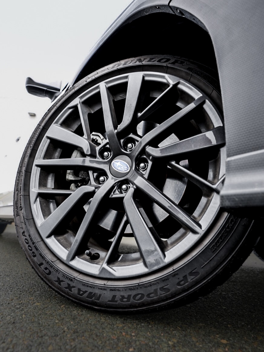 Close-up of a black alloy wheel and Dunlop Sport Maxx tire on a white Subaru WRX, highlighting the Subaru wheel emblem and performance-inspired design.
Gros plan sur une jante en alliage noire et un pneu Dunlop Sport Maxx d’une Subaru WRX blanche, mettant en valeur l’emblème Subaru et le design axé sur la performance.