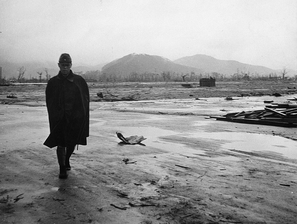 VoicesofWW2's tweet photo. Japanese soldier walking through a barren section of Hiroshima, Japan, September 1945 https://t.co/Y2RE7dc4Pz