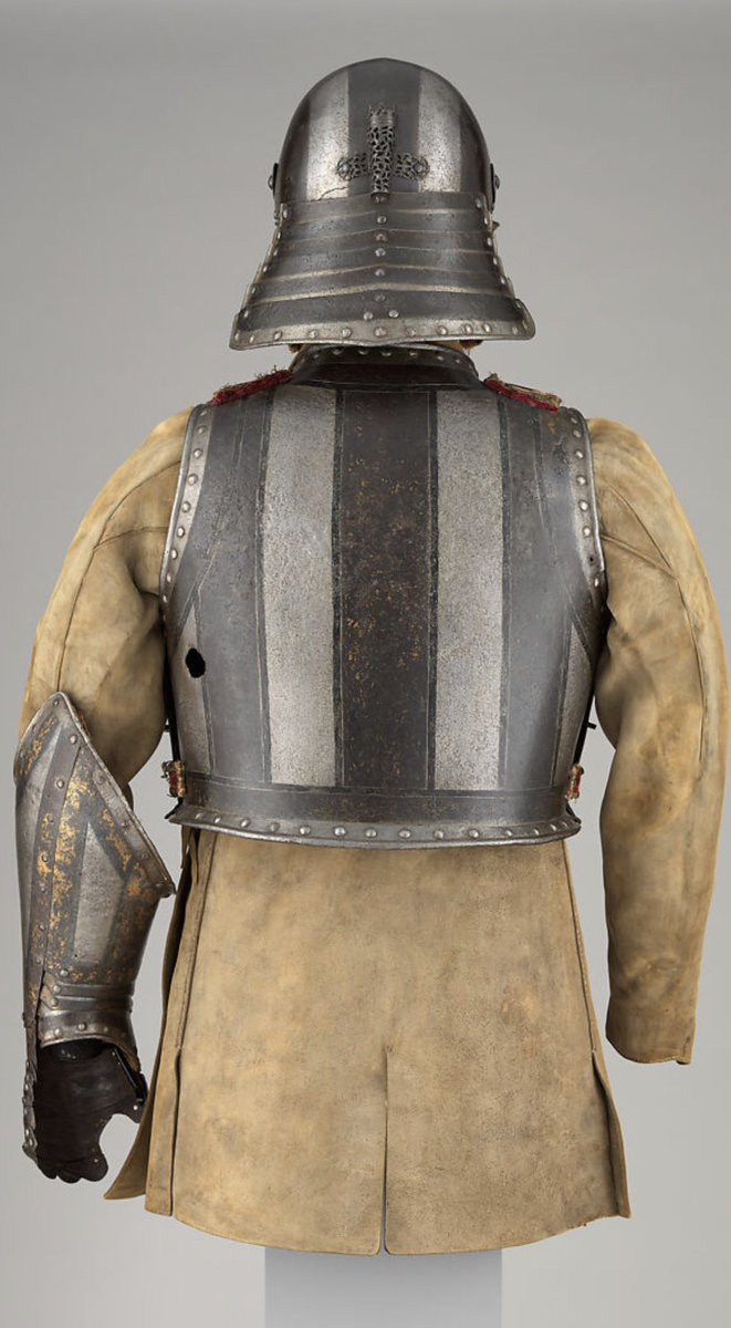 Argonaut1535's tweet photo. 🇵🇹🇬🇧Etched & Gilt Harquebusier's Armor of Pedro II, King of Portugal (reigned 1683–1706) with Buff Coat

Made in London by the British Armorer Richard Holden ca. 1683

This armor can be identified by its decoration as having belonged to Pedro II (reigned 1683–1706). The decoration includes the crowned monogram PR for Pedro Rex (Pedro the King) and the cross of the commander of the Order of Christ, a hereditary office held by the kings of Portugal.

Harquebusiers were armored cavalrymen generally equipped with a carbine (known as a harquebus) carried at the right side on a shoulder belt, a pair of pistols holstered at the front of the saddle, and a sword. 

This form of armor, consisting of a triple-barred helmet, a cuirass with a bulletproof reinforcing breastplate, and an elbow gauntlet, was commonplace in England up to about 1645. 

The armor of King Pedro is significant not only as a very late example of this type but also as the probable work of the London armorer Richard Holden. 

A very similar armor made by Holden in 1686 for James II of England (reigned 1685–88) is in the Royal Armouries in the Tower of London.

The armor is shown with an associated buff coat. This sturdy leather defense, which provided effective protection against sword cuts, was worn throughout the seventeenth century, first in conjunction with armor and later alone.

Dimensions: armor (15.113.1–.5): Wt. 43 lb. 5 oz. (19.6 kg)