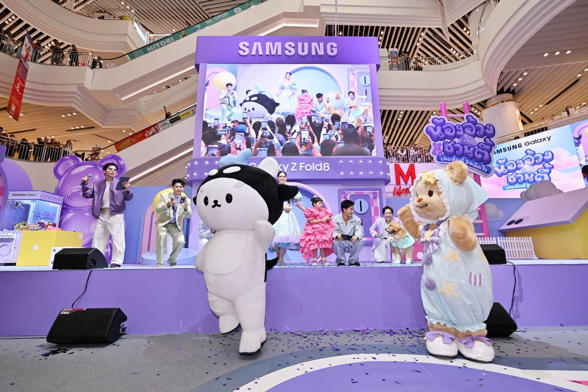 RainbowNewsent's tweet photo. สาดไปสมาชิก! ซัมซุงยกทัพ #TeamGalaxy แม่ชม-น้องเกล พี่จอง-คัลแลน เต ตะวัน-โพก้าซัง พร้อมแขกรับเชิญสุดพิเศษ มิสเตอร์ไบรอัน และ จุ๊มเหม่ง "น้องอ้วงชวนตี้ เล่นเต็มที่ ฮีลเต็มใจ" เปิดตี้อวดไอเทมใหม่ Galaxy Z Fold8

#น้องอ้วงชวนตี้
#GalaxyZFold8
#Samsung
#TeamGalaxy

กรุงเทพฯ – 19 กันยายน 2569 – ปีที่แล้วจัดหมูกระทะฟินๆ กันไปแล้ว ปีนี้กลับมาอีกรอบให้แฟนๆ หายคิดถึง มาฮีลใจไปด้วยกัน กับ "น้องอ้วงชวนตี้ เล่นเต็มที่ ฮีลเต็มใจ" ที่เดอะมอลล์ไลฟ์สโตร์ บางกะปิ ยกขบวนแก๊งฮีลใจตัวท็อปมารวมพลังกันแบบจัดเต็มยิ่งกว่าเดิม กับปาร์ตี้เปิดตัวสมาชิกใหม่ล่าสุดอย่าง "น้องอ้วง" Galaxy Z Fold8 สมาร์ทโฟนจอพับไซซ์ใหม่ ที่มาแรงแบบไม่มีกั๊ก

งานนี้นำโดย #TeamGalaxy แก๊งฮีลใจรุ่น 1 อย่าง “แม่ชม-น้องเกล” “พี่จอง-คัลแลน” และ “น้องเนย Butterbear” เสริมทัพด้วยแก๊งฮีลใจรุ่น 2 ทั้ง “เต ตะวัน” และ “โพก้าซัง” แถมพ่วงด้วยแขกรับเชิญสุดกวนอย่าง “มิสเตอร์ไบรอัน” และความน่ารักไม่มีขีดจำกัดของ “จุ๊มเหม่ง” ที่เข้ามาเพิ่มสีสันและความอุ่นใจเต็มพิกัด โดยมี "เผือก-พงศธร" รับหน้าที่พิธีกรมอบความสนุกตลอดงาน

ความสนุกเริ่มขึ้นตั้งแต่ก่อนงานจะเริ่มด้วยซ้ำ เมื่อมีการปล่อยคลิปฮาๆ ที่แก๊งฮีลใจรุ่น 1 โทรตามกำลังเสริมรุ่น 2 มาช่วยปั่นความสนุก ที่ “น้องเกล” โทรชวน “โพก้าซัง” ส่วน “น้องเนย” ก็โทรหา “พี่เต” ให้มาเล่นเกมเป็นเพื่อนกันแบบเต็มที่ในงาน "น้องอ้วงชวนตี้ เล่นเต็มที่ ฮีลเต็มใจ" สร้างเสียงหัวเราะให้แฟนๆ ชาวแก๊ง Galaxy

เมื่อถึงเวลาเริ่มงานก็เปิดเวทีด้วยความคิ้วต์ของ “น้องเนย” ที่วันนี้สวยและเก๋เป็นพิเศษเพราะถือกระเป๋า ‘RUBY’ Cushioned Organizer แฟชั่นไอเทมลิมิเต็ดเอดิชันที่ซัมซุงร่วมกับแบรนด์ PIPATCHARA ออกแบบเพื่อใช้ใส่ “พัพไซซ์ใหม่” อย่าง Galaxy Z Fold8 โดยเฉพาะ ตามด้วย “พี่จอง-คัลแลน” ที่ 2 หนุ่มพา “จุ๊มเหม่ง” มาทักทายแฟนๆ กันแบบใกล้ชิด สร้างบรรยากาศอบอุ่นให้ทั้งฮอลล์ตั้งแต่ต้น ฝั่งกำลังเสริมรุ่น 2 ทั้งปะป๊า “เต ตะวัน” และ “โพก้าซัง” ก็ไม่ยอมน้อยหน้า ที่เปิดตัวไม่ซ้ำใครจากบันไดเลื่อนก่อนขึ้นเวทีทักทายอุนย่า อุนยาย และเจ่เจ้ ด้วยความน่ารักไม่แพ้กัน

จากนั้นบรรยากาศก็ยิ่งฟินขึ้นเรื่อยๆ เมื่อมีเซอร์ไพรส์พิเศษให้ชาวแก๊ง Galaxy ที่มีวันเกิดตรงกับวันงาน โดยพี่จองและคัลแลนลงไปมอบของขวัญพร้อมอัดคลิปอวยพรด้วย Galaxy Z Fold8 กันสดๆ ให้แฟนๆ กรี๊ดลั่นฮอลล์ ต่อด้วยช่วงเกมสุดป่วนอย่าง "อ้วงพันหน้า" แบ่งเป็น 2 ทีม คือทีม "ปะป๊าเต-โพก้าซัง" ปะทะทีม "พี่จอง-คัลแลน-น้องเนย" ให้แต่ละทีมแต่งหน้าแต่งตัวสลับกันทายว่าเป็นใคร พร้อมชวนแฟนๆ ในงานร่วมทายไปด้วย เรียกเสียงหัวเราะได้ตลอดเกม จากนั้นแต่ละทีมยังต้องโพสท่า Signature Pose และเต้นถ่าย VDO ด้วยโหมด Dual Camera Record กันสดๆ แถมโชว์การส่งภาพที่ถ่ายบนเวทีด้วยฟีเจอร์ Quick Share ให้แฟนๆ กลางฮอลล์ได้แบบง่ายๆ ได้กับทุกระบบปฏิบัติการ ทำเอาพี่เผือกต้องขอหยิบเอาน้องอ้วงพับไซซ์ใหม่มาทดลองความคมชัดของวิดีโอที่ถ่ายด้วยโหมด Dual Record กันสดๆ บนเวทีให้แฟนๆ ได้เห็นกันแบบเต็มๆ ตา

ไฮไลต์สุดฮายกให้ช่วงของ “จอง-คัลแลน” “เต ตะวัน” ขึ้นเวทีคุยกัน เพราะยิ่งคุยก็ยิ่งงง คนละทิศละทางจนต้องประกาศขออาสาสมัครล่ามภาษาเกาหลีที่อยู่ในงานมาช่วยแปล ซึ่งก็คือ “มิสเตอร์ไบรอัน” บนเวทีจึงกลายเป็นแก๊ง 3 หนุ่มเกาหลี 3 สไตล์ เดบิวต์บอยแบนด์เฉพาะกิจ ช่วยกันถ่ายรูปกันรัวๆ หลายๆ ช็อต

ส่วน “น้องเกล” ที่เพิ่งเลิกเรียนก็รีบมาร่วมแจมพร้อม “แม่ชม” ทำเอาบรรยากาศคึกคักขึ้นไปอีก จากนั้น “น้องเกล” ก็ชวนแฟนๆ มาเล่นเป่ายิงฉุบ ใครชนะรับไปเลยของรางวัลในทีม “อ.อ้วง” ที่แม่ชมเตรียมมาแจกแบบแน่นๆ แถมน้องเกลยังใจดีแถมเงินให้อีก 20 บาทอีกด้วย

ด้วยความเป็นตัวแม่ฟิตแอนด์เฟิร์มของ “แม่ชม” จึงได้เตรียมเซอร์ไพรส์พิเศษแจก Galaxy Watch9 สมาร์ทวอทช์ที่บอกสัญญาณความเสี่ยง เบาหวาน หัวใจ อัลไซเมอร์ สโตรก ให้ชาวแก๊ง Galaxy ที่ชนะ 3 ภารกิจพิเศษ เอาไปใส่ดูแลสุขภาพเชิงป้องกัน

ปิดท้ายค่ำคืนนี้แบบฟินสุดๆ ด้วยการถ่ายรูปหมู่ร่วมกัน และเต้นเพลง Happy Family นำโดย “โพก้าซัง” ต่อด้วยเพลง Butterbear ของ “น้องเนย” และปิดท้ายด้วย I'm Polcasan จาก “น้องเกล” และ “โพก้าซัง” สร้างความประทับใจให้ชาวแก๊ง Galaxy รวมถึงอุนย่า อุนยาย เจ่เจ้ ทุกคนกลับบ้านแบบใจฟูกันถ้วนหน้า!