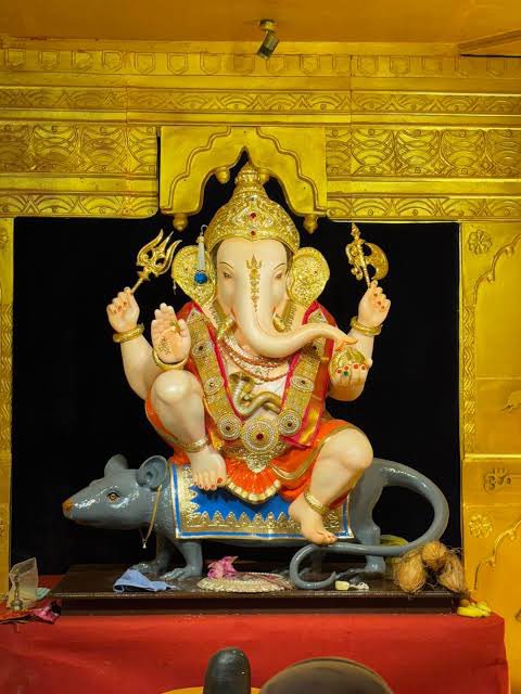 omganesh88999v2's tweet photo. พระพิฆเนศอันทรงเกียรติลำดับที่3 แห่งเมืองปูเน่ค่ะ ที่มีชื่อว่า ‘Guruji Talim Ganapati’ ซึ่งจะอยู่ในขบวนแห่ ในช่วงเทศกาลคเณศจตุรถีนี้ด้วย ลักษณะเด่นคือ องค์พระพิฆเนศ จะนั่งประทับอยู่บนหนูมุสิกกะ ซึ่งถือเป็นบริวารเอกของพระองค์ เสมือนเป็นเลขาที่คอยตามติด ทำหน้าที่เป็นสื่อกลาง ส่งต่อคำอธิษฐานจากสาวกทั้งหลายถึงองค์พระพิฆเนศ ตอนที่ไปอินเดีย นอกจากจะเห็นคนนำขนมมาถวายพระพิฆเนศแล้ว เขาก็ยังนำมาให้พี่หนูด้วยค่ะ เหมือนแบบ กระซิบขอพร แล้วก็วางขนมหนึ่งชิ้น แบบนี้ค่ะเป็นการแลกเปลี่ยนกัน หรือบางทีก็หยิบขนมจากพี่หนูกลับบ้านไปด้วยเพื่อเป็นสิริมงคล #คเณศจตุรถี2026