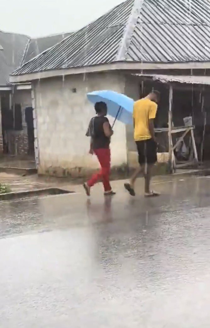 instablog9ja's tweet photo. Man proves his love as he gets drenched in heavy rain while his lady stays dry under the umbrella https://t.co/7uvWnTdlEY