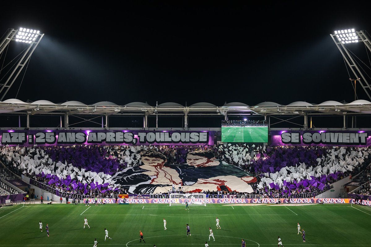 ToulouseFC's tweet photo. 𝑻𝒐𝒖𝒍𝒐𝒖𝒔𝒆 𝒏'𝒐𝒖𝒃𝒍𝒊𝒆 𝒑𝒂𝒔

Il y a 25 ans, à 10h17, l’explosion d’AZF marquait notre ville à jamais et bouleversait les Toulousaines et les Toulousains.  

Elle touchait aussi profondément le Club, le Stadium, ses joueurs et ses Pitchouns de l’époque, à l’image de Cyril Dubroca et Jérémy Moreau, représentés sur le tifo réalisé par nos supporters.  

Le Club adresse ses plus sincères pensées aux familles et aux proches des victimes 🕊️🖤
