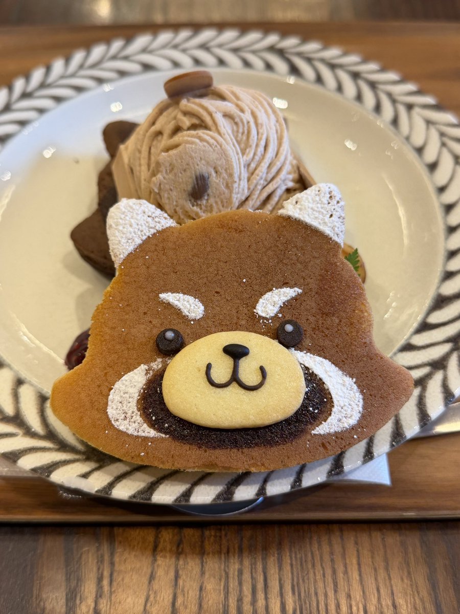 PancakesToshi's tweet photo. 目黒区碑文谷『henteco森の洋菓子店』さん

9/4〜期間限定
「レッサーパンダパンケーキ」

レッサーパンダ型のココア生地とプレーン生地を使い、レッサーパンダの威嚇クッキーを【乗せる】か【サンドする】か、味は【季節限定】【チョコバナナ】【モンブラン】の三種類から選べます

写真のは、【サンド】＋【モンブラン】です😄

生地はふわしっとりしており、栗のモンブランクリームと生クリーム、カシスソース、ナッツ、おさつチップが添えられています✨

レッサーパンダクッキーが手を挙げて威嚇しているので、持ち上げているように見えますね😁パンケーキもレッサーパンダ顔になっており、可愛らしく美味しくいただきました😋

おじさん一人で行ってきました👨笑