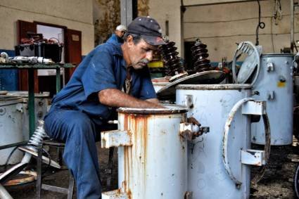 YaquedeCuba's tweet photo. Calor, sudor y hollín:
Hombres que luchan contra la escasez, reconstruyendo transformadores con ingenio y manos curtidas. #CubaNoSeRinde 
Donde falta la pieza, sobra la voluntad #CubaNoEsUnaAmenaza, el Bloqueo Si. https://t.co/h5gHA1ZfRC