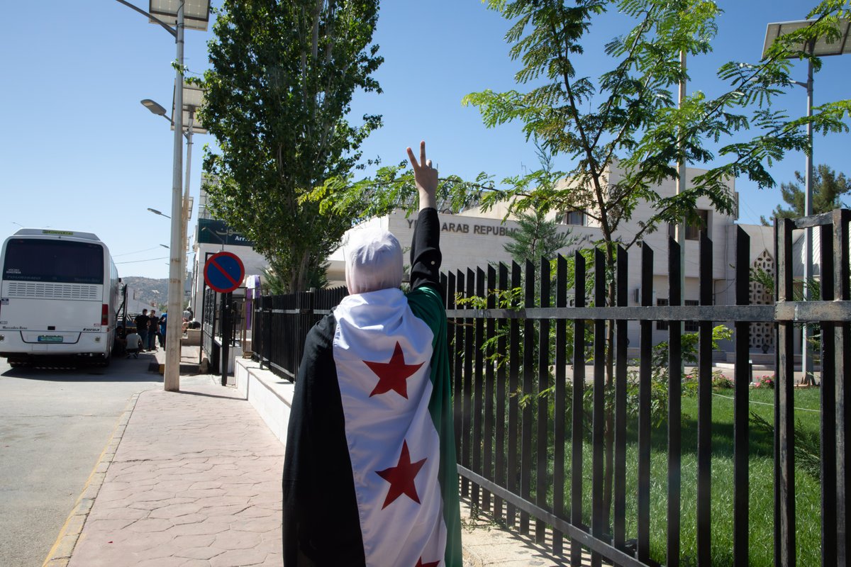 Taghreed, con la bandera siria, en el paso fronterizo de Jdaidet Yabous mientras regresa a Siria desde Líbano.
Fotografía: © ACNUR/Vivian Toumeh