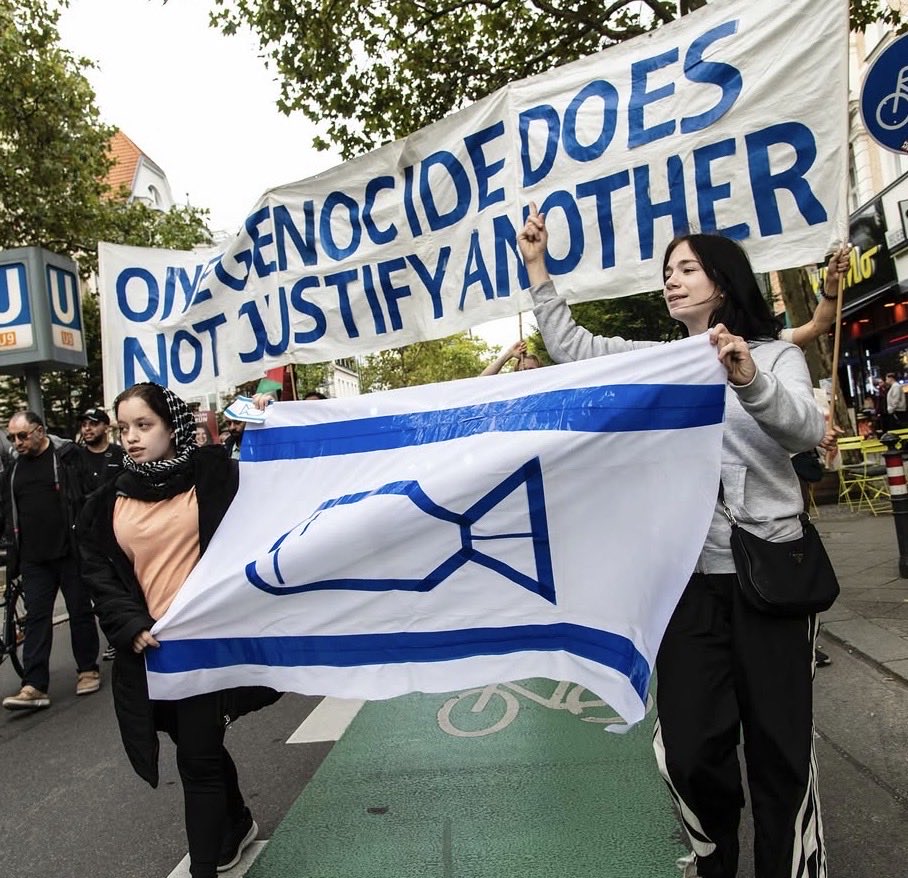 Alerts_CAM's tweet photo. 🇩🇪 Berlin, Germany. September 19.

Protesters replaced the Star of David on Israel’s flag with a bomb while declaring, “One genocide does not justify another.”

This is Holocaust inversion. It exploits the murder of six million Jews to portray the Jewish state and its national symbol as instruments of genocide.