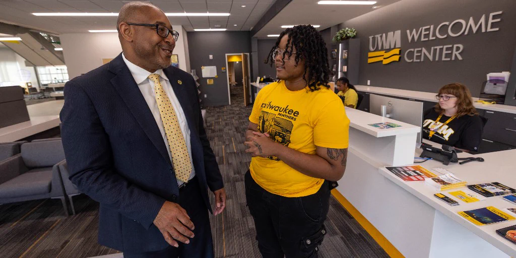 UWM Chancellor Gibson smiles and talks with student Jordan Bryant, an orientation leader with the Office of Undergraduate Admissions.