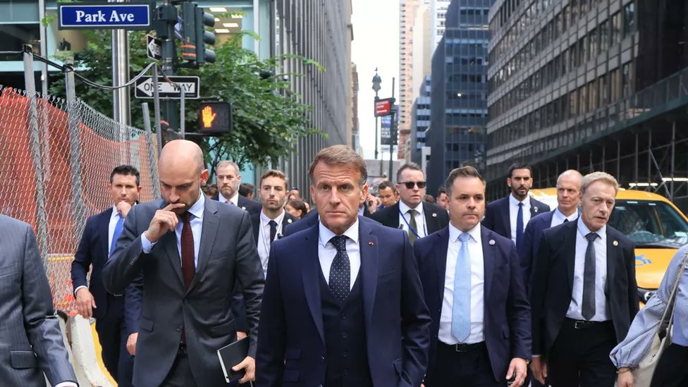 LilianeR519950's tweet photo. Macron résumé en une image : arrogant, se prend pour le maitre du monde entouré de ses laquets ministériels, à "faire le beau" dans les rues de New York pétri de son importance.  
Mais ... Mort de trouille ! Le torse est bombé de son gilet pare-balles, il est entouré d'une horde de gardes du corps, le visage est crispé, le front strillé de rides en vagues tendues ... 
A t'il son tic de main dans la poche, de fausse décontraction, pour stabiliser ses éruptions caractérielles ou cacher ses tremblements de plus en plus fréquents ? 
Ce bouffon maléfique est de plus en plus ridicule !
