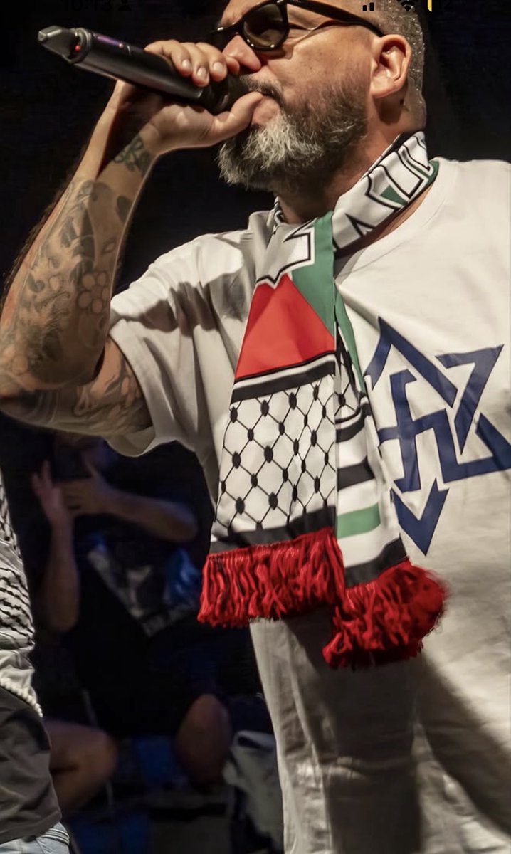 Alerts_CAM's tweet photo. 🇪🇸 Parla, Spain. September 20.

Singer Azeta appeared on stage wearing a shirt that merged the Star of David with a Nazi swastika, alongside a Palestinian scarf.

Equating the Jewish symbol with the emblem of the regime that murdered six million Jews is Holocaust inversion. It demonizes Jews and trivializes the crimes of Nazi Germany.