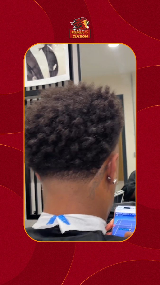 A man with tight curls and a fresh fade haircut sits in a barber's chair scrolling on his phone, fitting the caption's description of "Ismail Jakobs scrolling through Reels while shaving." The image is branded with a "Forza Cimbom" lion logo, suggesting a connection to Galatasaray, where Jakobs plays.