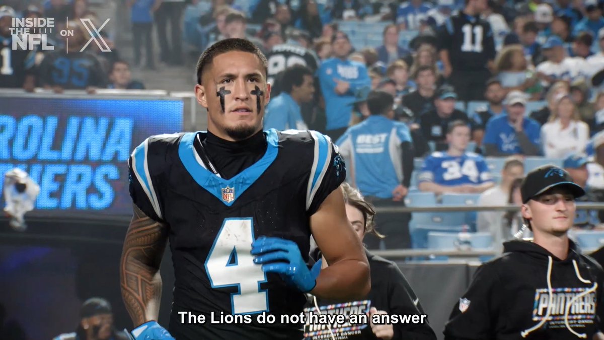 Carolina Panthers wide receiver #4 walks off the field in his black and blue uniform with eye black, as the caption reads "The Lions do not have an answer" — referencing Tetairoa McMillan's standout performance on Sunday Night Football.
