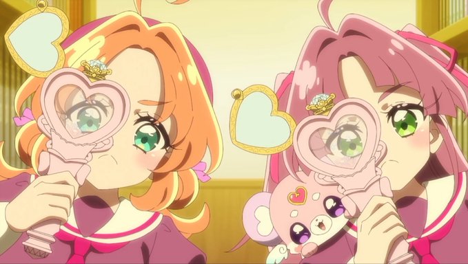 An anime scene showing two characters, one with orange hair and one with pink hair, holding heart-shaped pink hand mirrors.