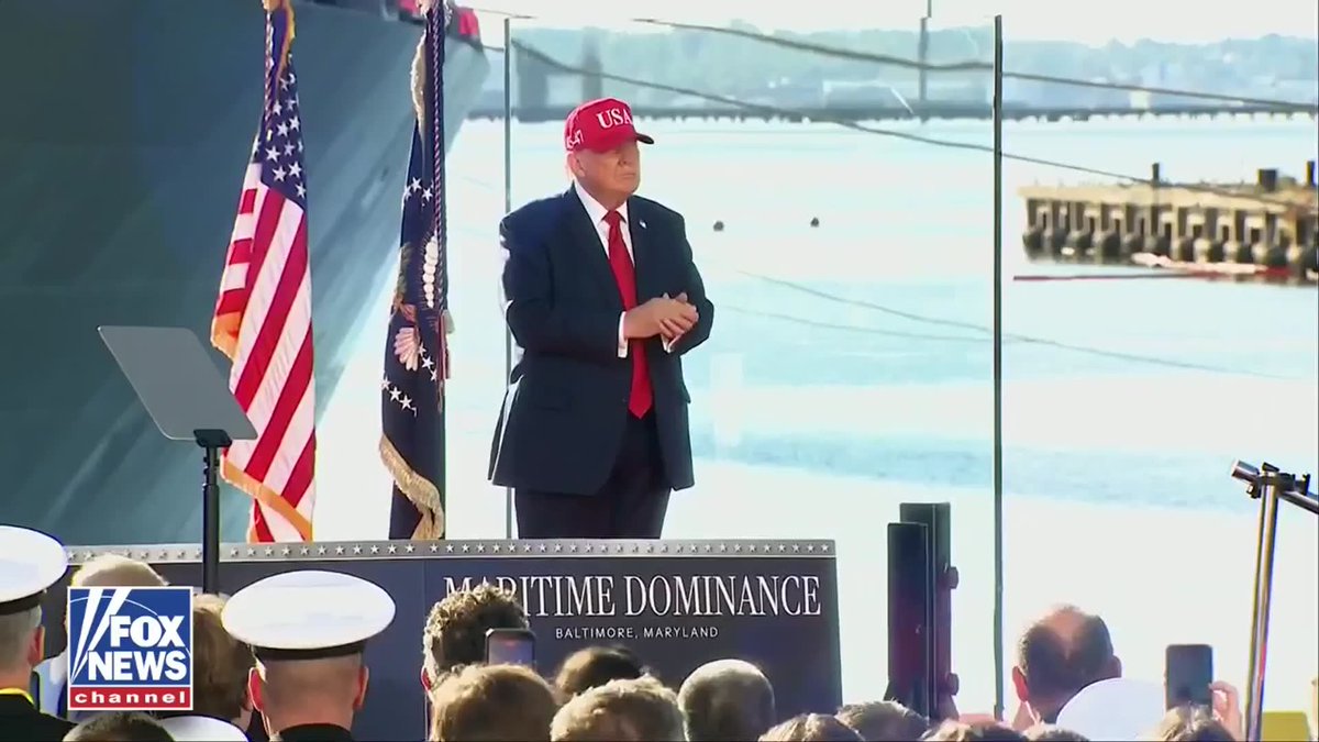 Donald Trump wearing a red 'USA' cap stands at a podium with American flags and a 'MARITIME DOMINANCE BALTIMORE, MARYLAND' sign, broadcast by Fox News Channel.