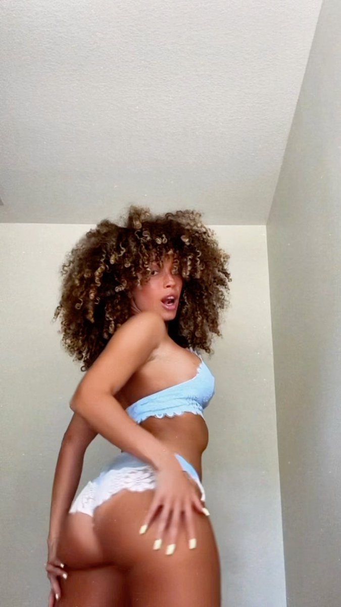 A woman with voluminous curly hair, wearing light blue lingerie, poses provocatively, implying a connection to the provocative question in the accompanying post about "OLD pussy vs NEW pussy."