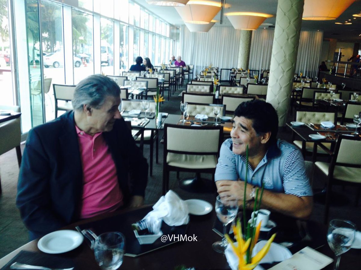 VHMok's tweet photo. ¿Recuerdan "De Zurda"? Así lo armamos. 

Esta secuencia de fotos de 2014, fue cuando nos reunimos por primera vez, en Río de Janeiro, en el hotel donde se alojaba Diego, para empezar a delinear lo que se vendría. ⚽️❤️

Habíamos ideado aquel programa -que iba a empezar dos días después- para hablar de fútbol, felices, de cómo iba a ser, pero con Diego siempre ocurría algo más. Bastaba que apareciera por la puerta para que la televisión dejara de ser televisión y se convirtiera en una conversación que se prolongaría toda la noche. Siempre con alegría.

Yo lo veía llegar al IBC, rodeado de cámaras, periodistas, custodios, gente que quería saludarlo, tocarlo, fotografiarlo. No podía caminar unos metros sin que el mundo se abalanzara sobre él. Y, sin embargo, cuando entraba al estudio, cuando se sentaba, cuando comenzábamos a hablar, aparecía otro Diego. El de la risa fácil. El de la memoria prodigiosa. El que podía pasar de Messi a Pelé, de una final del Mundial a una historia de su infancia, en apenas unos segundos.

A Diego había que dejarlo ir gambeteando por donde quisiera. Ahí estaba la magia. En ese pique corto aparecía el recuerdo que nadie había preparado, la anécdota que no estaba en ningún guión, la palabra que solamente podía decir él.

Lo vi emocionarse con una carta de Fidel. Lo vi recordar a su madre al escuchar aquel relato de México 86. Lo vi reírse de sí mismo, de nosotros, del fútbol y de todo aquello que el fútbol había puesto en su camino.

Y también lo vi cansado de que lo persiguieran. Era el hombre intentando tener cinco minutos de vida privada mientras el mundo entero quería un pedazo suyo.

Qué paradoja: nosotros habíamos ido a Brasil para tener a Maradona en un programa y terminamos teniendo el privilegio de compartir al hombre detrás del personaje.

De Zurda fue fútbol. Fue Mundial. Fue televisión. Pero para mí fue, sobre todo, la posibilidad de sentarme junto a Diego y escucharlo.

Porque uno vuelve a aquellas imágenes y comprende que no estaba simplemente mirando a un campeón del mundo. Estaba escuchando a Diego. Al único. Al Diez. Y qué regalo fue. ❤️⚽️