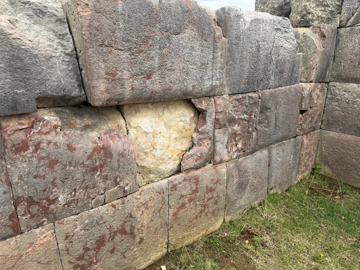 TheProjectUnity's tweet photo. The reddish "outer layer" of this block in Peru is breaking away, revealing what appears to be a different type of stone beneath it. 

On the adjacent rock (left) the reddish layer is thinning near the top, as if it had been plastered on, but this is stone... not plaster. https://t.co/pIQoeml36X
