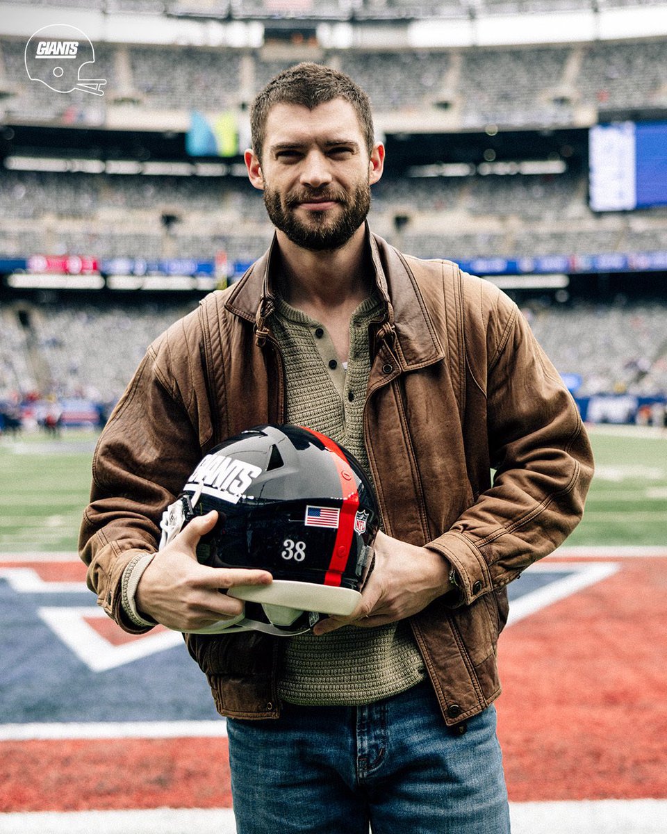 popbuzzz_'s tweet photo. David Corenswet on the field at a New York Giants game, holding up a blue Giants jersey labeled “MR. IRRELEVANT” with number 38, as part of promotional press for his upcoming film.

Corenswet stars as John Tuggle, the 1983 NFL draft’s final selection by the Giants, in the biographical sports drama ‘Mr. Irrelevant’, directed by Jonathan Levine and co-starring Michael Shannon as coach Bill Parcells.

The film, scheduled for theatrical release on December 25, 2026 by Paramount, tells Tuggle’s underdog story of making the roster before his tragic death from cancer at age 25, with this event continuing the press tour after the trailer’s September release.