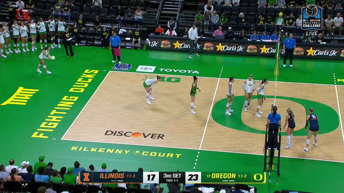 A volleyball match at the Discover Volleyball Challenge between Illinois and #17 Oregon on Kilkenny Court, with Oregon leading 23-17 in the 3rd set, played at the University of Oregon's arena with Fighting Ducks branding.