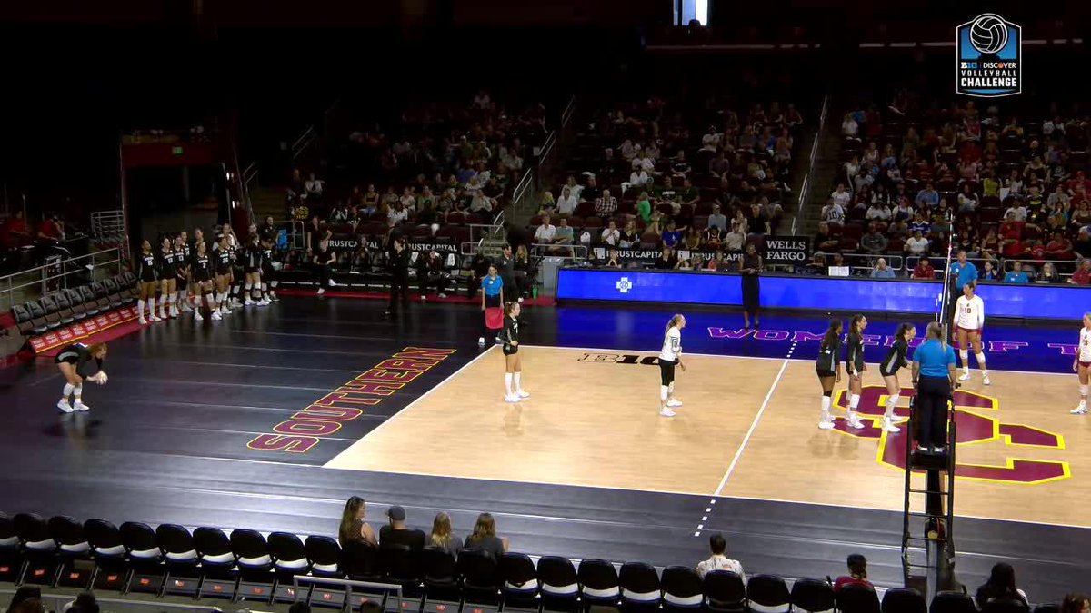 A volleyball match between USC and Nebraska women's teams is underway at the AVCA Volleyball Challenge in a packed arena, with 'RUST CAPITAL' and 'WELLS FARGO' signage visible.