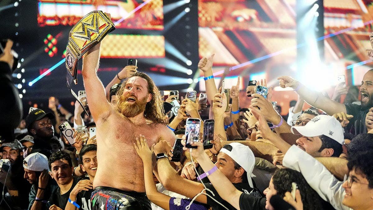 DFW_Wrestling's tweet photo. @MattDFW1 @NathanLeeDFW He walks to the outside, Raising the world title up high, celebrating with the fans. Making sure they are just as much a part of the moment as him. He gets in the middle of the crowd. Showing off the World Heavyweight Championship to the camera. https://t.co/5tEFYFA0Lf