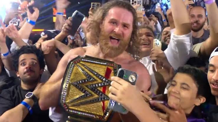 DFW_Wrestling's tweet photo. @MattDFW1 @NathanLeeDFW He walks to the outside, Raising the world title up high, celebrating with the fans. Making sure they are just as much a part of the moment as him. He gets in the middle of the crowd. Showing off the World Heavyweight Championship to the camera. https://t.co/5tEFYFA0Lf