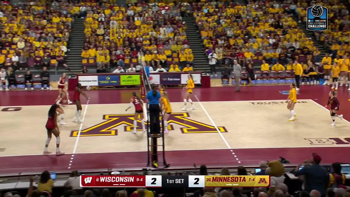 A women's volleyball match between Wisconsin and Minnesota tied 2-2 in the 1st set, with the scoreboard showing Wisconsin at 6 (9-4) and Minnesota at 20 (7-4) during a Discover Volleyball Challenge event.
