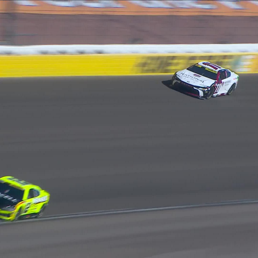 A NASCAR race car with "NATIONAL" branding spins sideways across the track while another yellow car (No. 11) races by below, capturing the moment Denny Hamlin avoids crashing into the wall during a spinout.