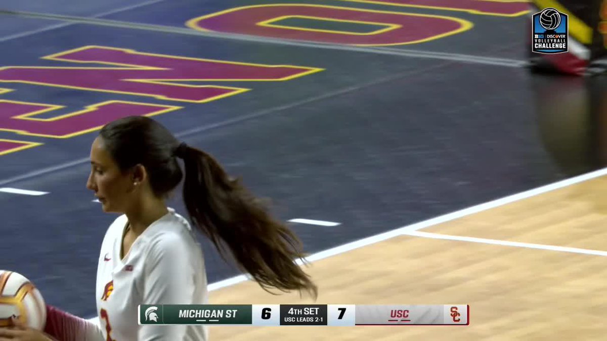 USC women's volleyball player with a long ponytail on the court, with the scoreboard showing Michigan State trailing USC 6-7 in the 4th set, with USC leading 2-1.