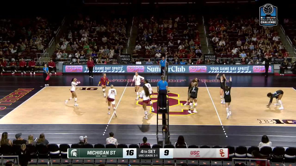 A college volleyball match between Michigan State (16) and USC (9) is underway in the 4th set, with USC leading the series 2-1, played on a court featuring a large 'SC' logo and Summer Club advertisements.