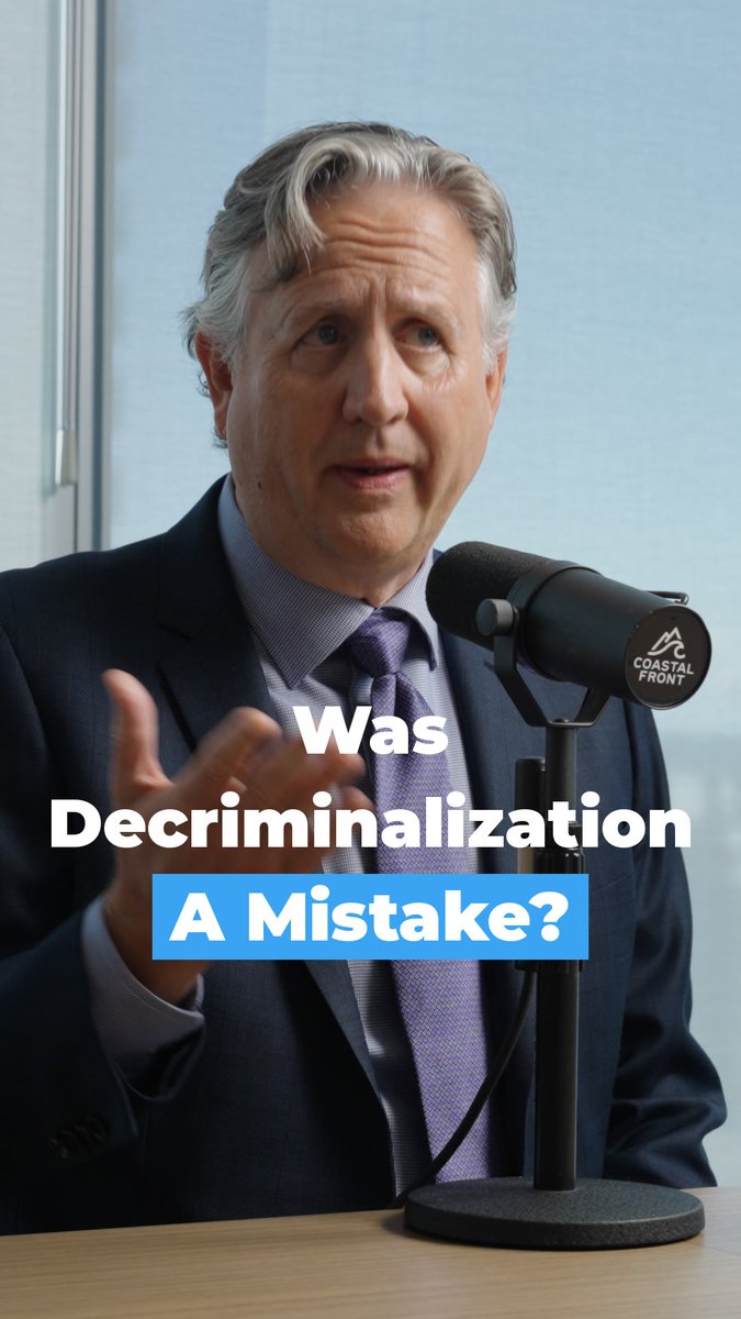 An older man in a suit and purple tie speaks into a microphone labeled 'COASTAL FRONT', with text overlay reading 'Was Decriminalization A Mistake?'