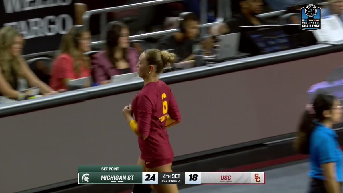 Michigan State volleyball player #6 in a maroon jersey preparing to serve, with the scoreboard showing Michigan State at 24, USC at 18 on set point in the 4th set, USC leading 2-1.