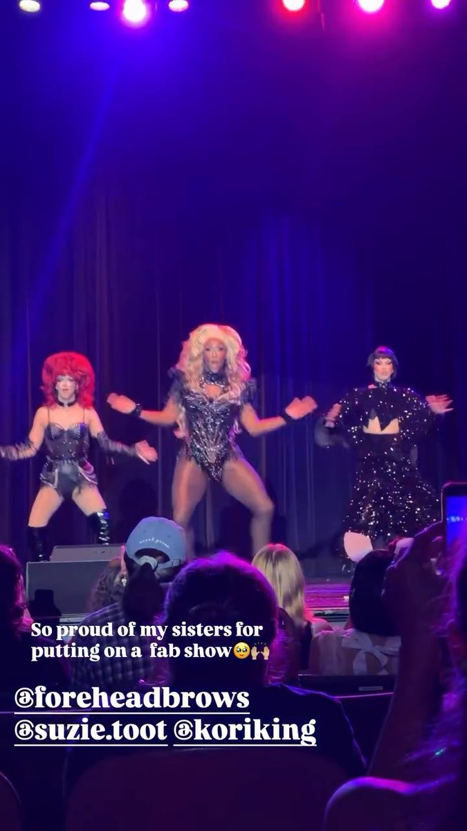 A drag performance on a purple-lit stage with three performers in elaborate costumes and wigs, with a caption reading "So proud of my sisters for putting on a fab show 🥺🙌" tagged @foreheadbrows, @suzie.toot, and @koriking.