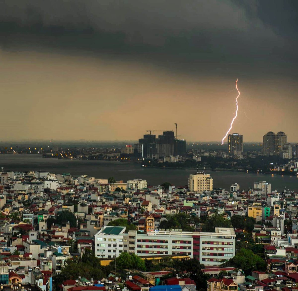 pelondani90's tweet photo. Hanoi has shifted from light grey months to the dramatic dark skies of storm season. Schools are closed again, so I’ll be on the balcony watching the storms. https://t.co/42bnb11kuB