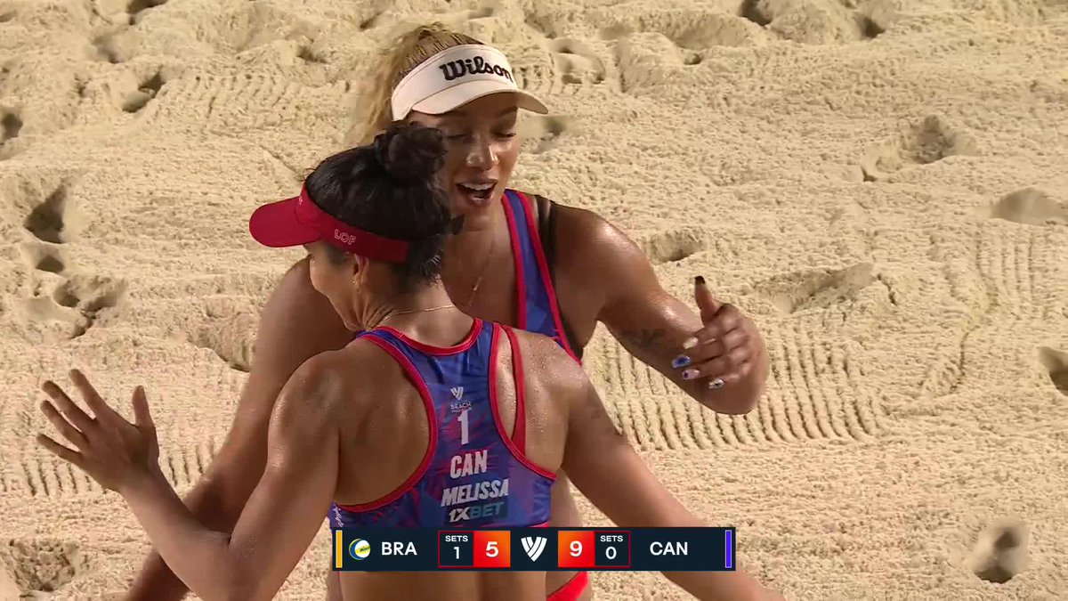 A sports broadcast screenshot showing two female beach volleyball players from Canada embracing on the court, where Brazil leads Canada 5-9 in the first set, with one player wearing a jersey labeled 'CAN MELISSA'.