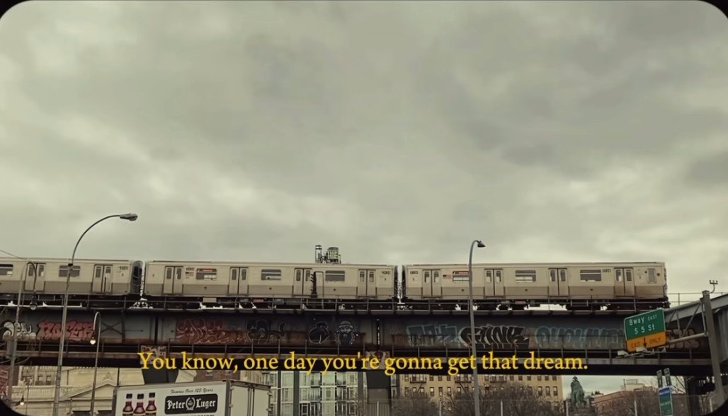 An elevated subway train travels across a graffiti-covered bridge under a cloudy sky, with the caption "You know, one day you're gonna get that dream." and signs visible for the BQE and Sway 435 St.