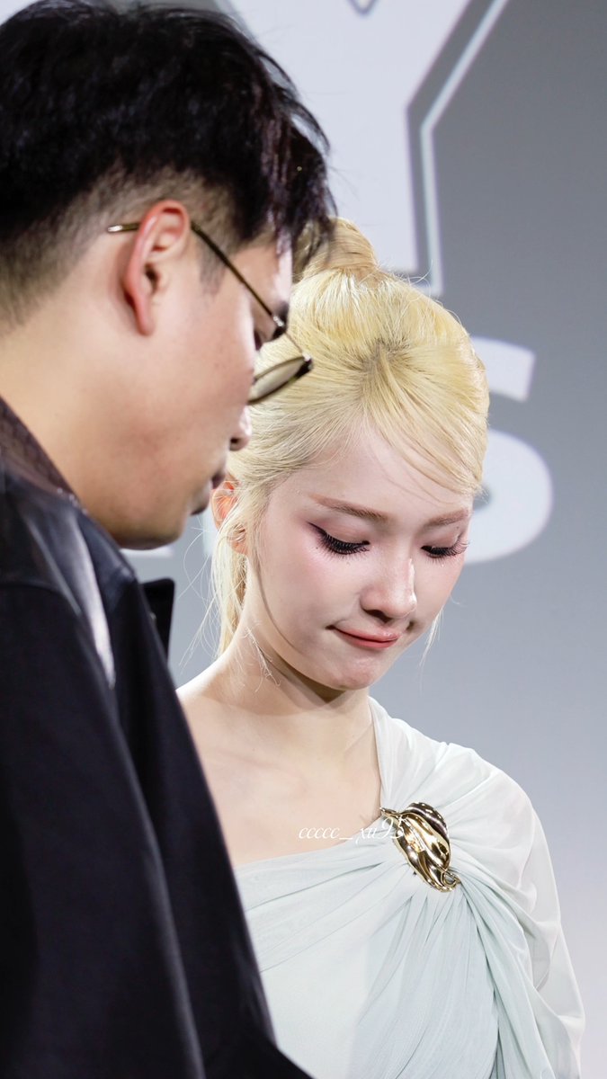 The photo shows a blonde woman in an elegant pale gown with a gold shell brooch, standing next to a man wearing glasses, likely at a fan event. The watermark "ccccc_yu3" appears on the image, which aligns with the accompanying post celebrating "JJJ BONJOUR PARIS" for Jan Janejira's Fan Day in Paris.