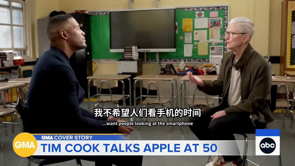 A Good Morning America interview clip titled 'GMA COVER STORY: TIM COOK TALKS APPLE AT 50' featuring Tim Cook speaking with a journalist in a classroom setting, with subtitles reading '我不希望人们看手机的时间' and '...want people looking at the smartphone'.