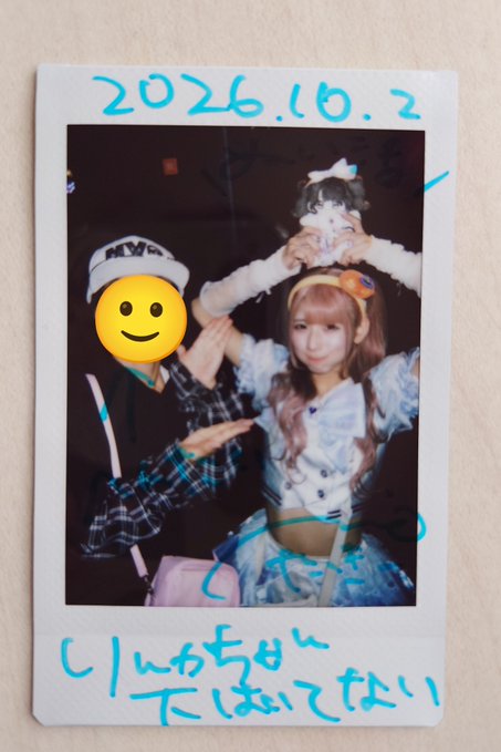 A Polaroid photo dated '2026.10.2' shows a person in cosplay and another individual whose face is covered by a yellow smiley face sticker, with handwritten Japanese text in blue marker at the bottom.