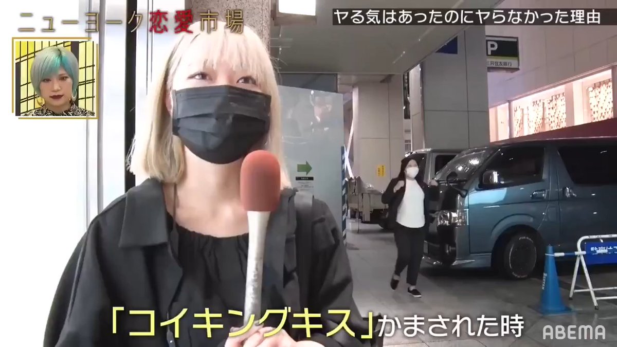 A Japanese news segment from ABEMA featuring a blonde woman wearing a black mask being interviewed with a microphone, with Japanese text about unique dating markets and being kissed on the cheek.