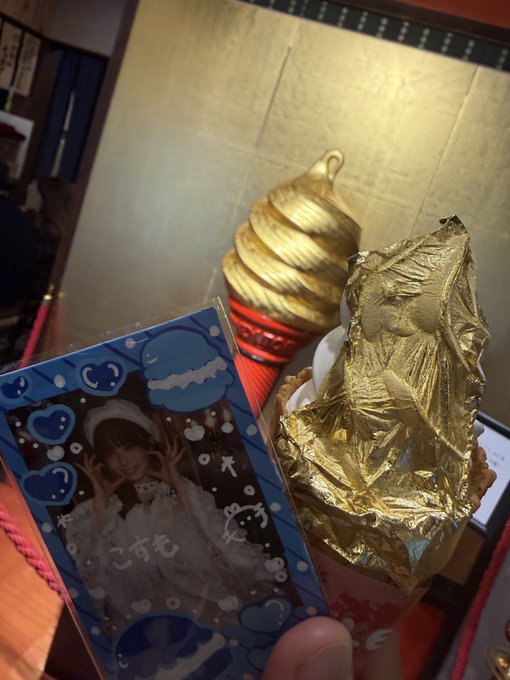 A photo card of a young woman is held next to a real gold leaf ice cream cone, with a golden swirl soft serve decoration visible in the background.