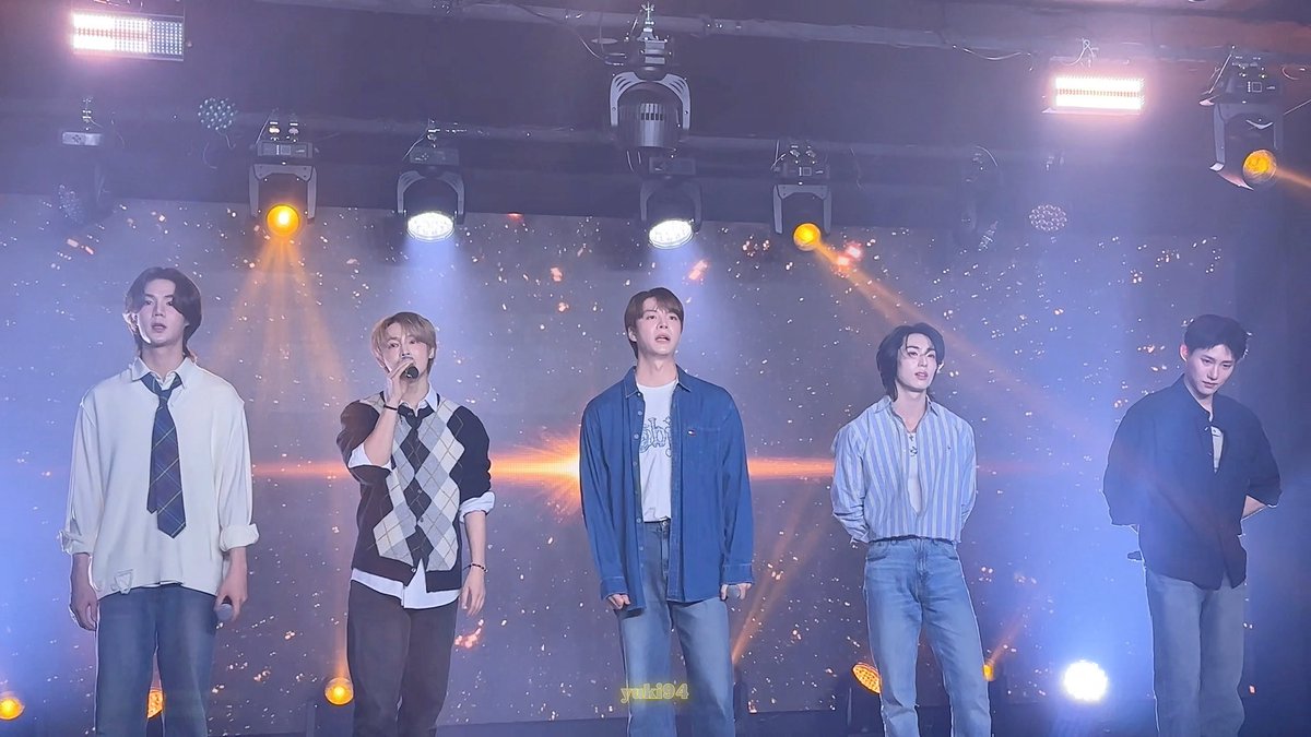 Five male performers stand on a stage under bright spotlights, one singing into a microphone, with a 'yuki04' watermark.