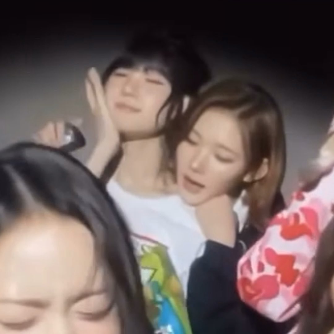 A blurry selfie-style photo shows a group of young women posing closely together, with one wearing a colorful graphic t-shirt and others with dark hair, capturing a candid, playful moment that fits the post's cheerful reference to "Jiu Kobuk" and the lighthearted "Universe" vibe.