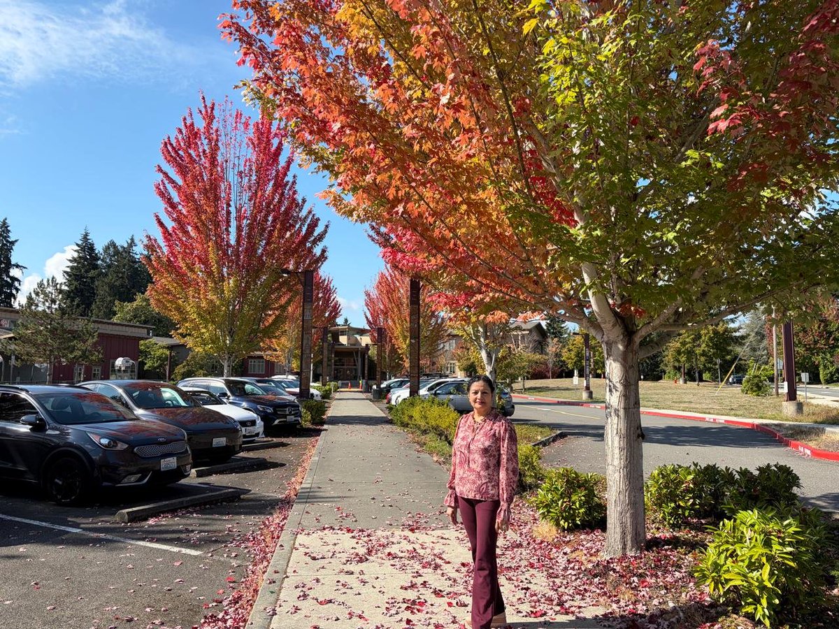 lakshmiunwomen's tweet photo. The Fall of Colours
Seattle, in a fall of colours — and for a while, I stood inside autumn’s own masterpiece.

The city caught fire without a flame-
the trees simply remembered how to glow.
Crimson climbed the branches,
amber spilled into the afternoon,
and every leaf became a little sunset
refusing to leave quietly.

Autumn had arrived like a master painter,
dipping its brush in wine, copper and gold,
turning ordinary streets into galleries
and pavements into carpets of fallen light.

I stood beneath that burning canopy
and watched summer loosen its hold—
not with sorrow, but with splendour.

Perhaps that is autumn’s loveliest wisdom:
that letting go need not be colourless;
sometimes, the most beautiful fall
is the one that leaves the world ablaze. 🍁