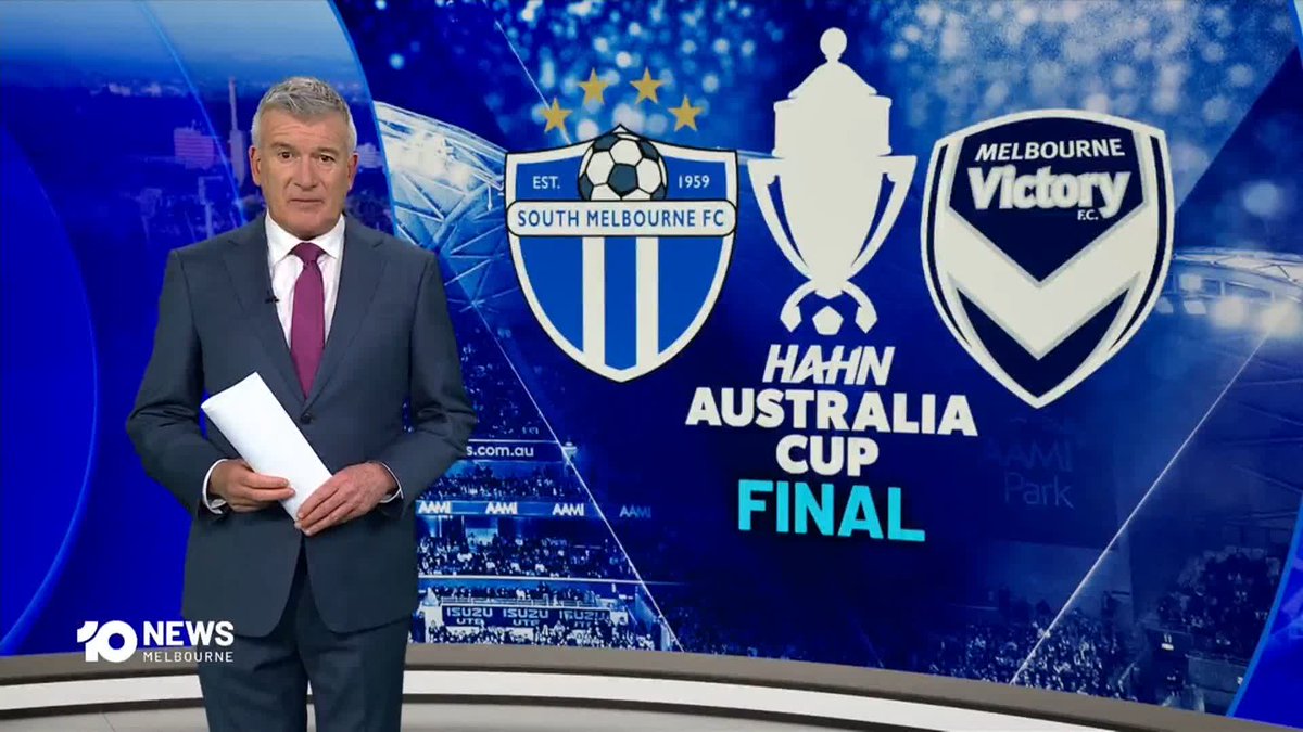 A male news anchor in a suit stands in a studio in front of a screen displaying the 'HAHN AUSTRALIA CUP FINAL' logos for South Melbourne FC and Melbourne Victory FC, with '10 NEWS Melbourne' branding.