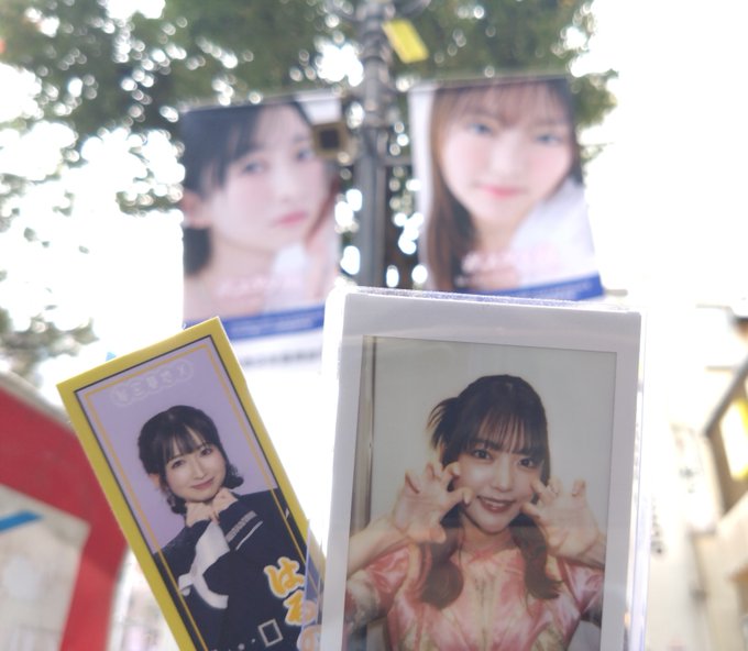 Polaroid and trading card photos of a young woman displayed outdoors with blurred banners in the background.