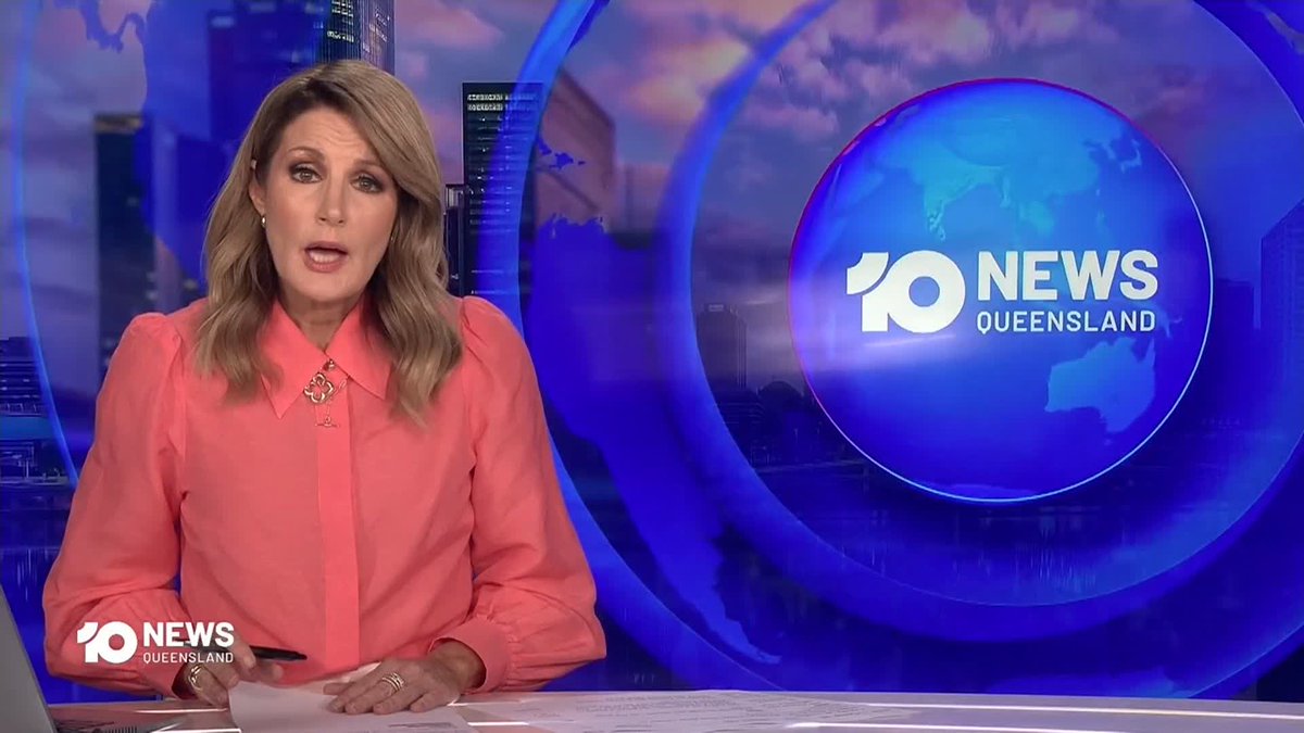 A female news anchor with blonde hair wearing a bright pink blouse delivers the news at a studio desk, with the "10 NEWS QUEENSLAND" logo and a blue globe graphic displayed prominently on the right.