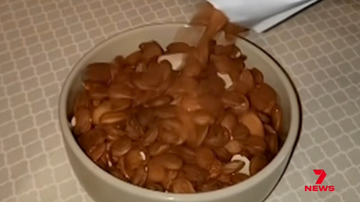 A white ceramic bowl sits on a tiled surface, filled with roasted nuts being poured into it from above, with a "7 NEWS" logo in the corner. The image illustrates the type of nutritional food content circulating online that experts warn breast cancer patients should be cautious of, given that nearly 90% of such nutrition advice online is unreliable.